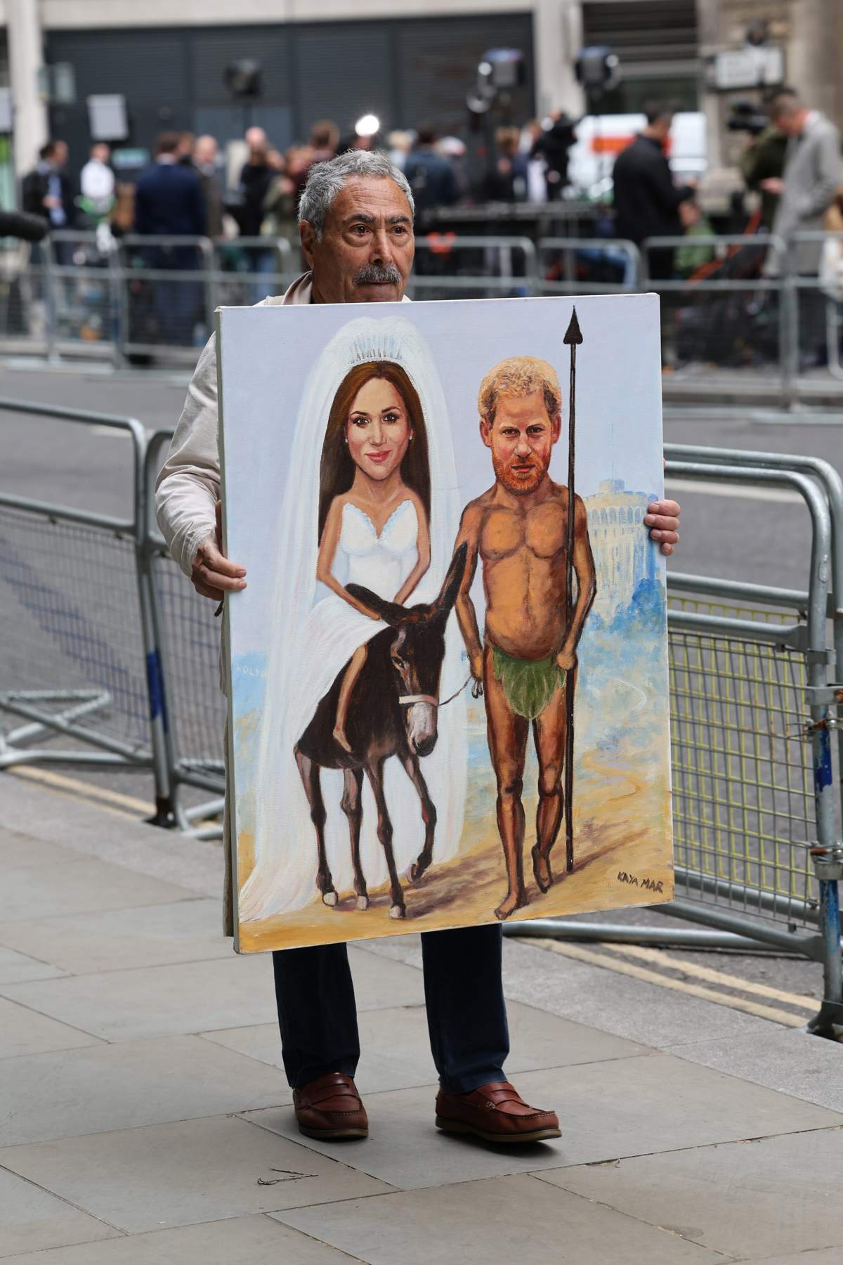 Hombre con cartel de Meghan y Harry