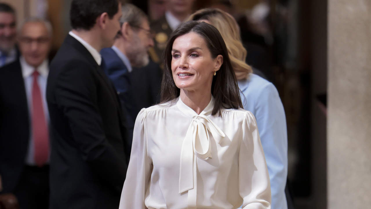 La reina Letizia, arrebatadora con los pantalones carrot efecto piel ideales para ir moderna con blusa blanca a los 50