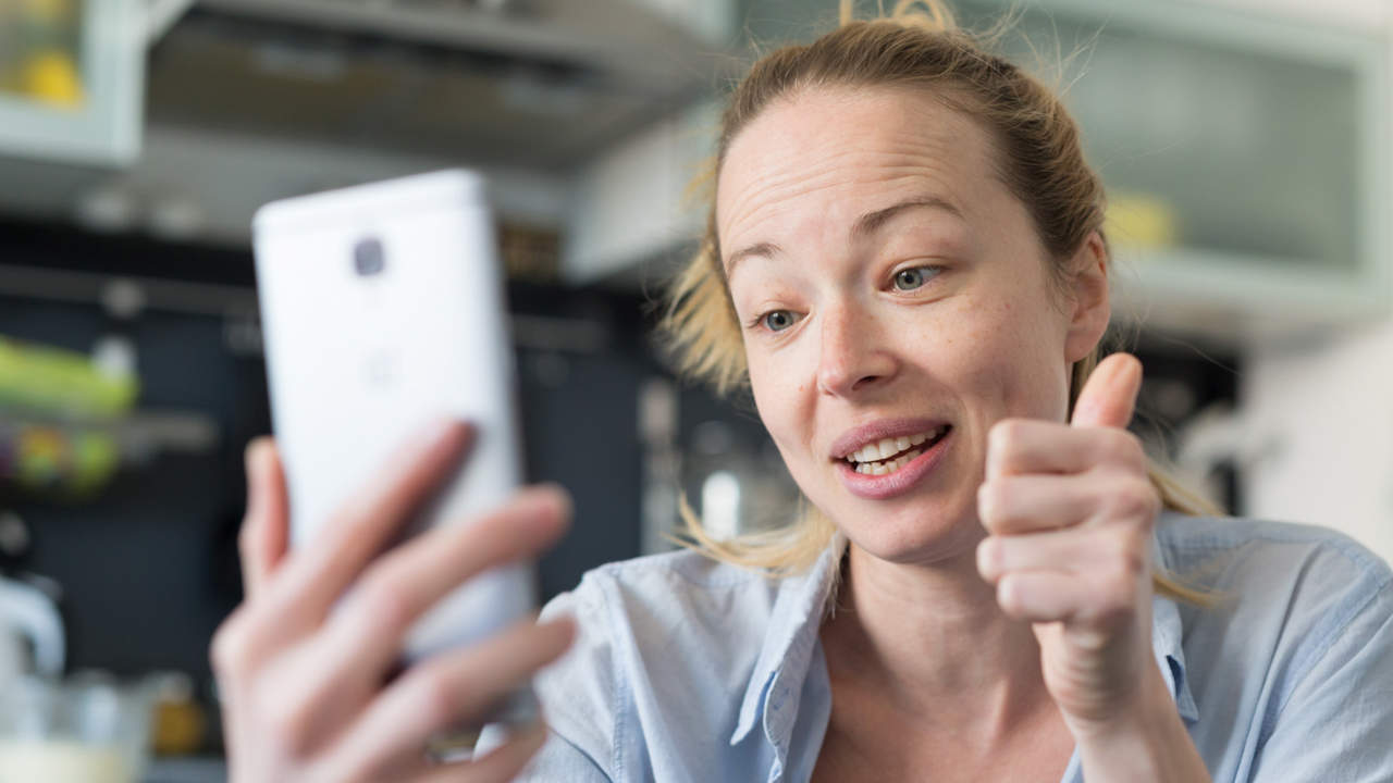 Mujer haciendo un gesto mientras habla por teléfono