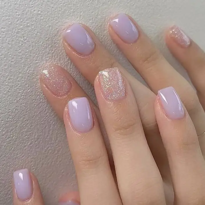 Uñas pastel con acento de purpurina