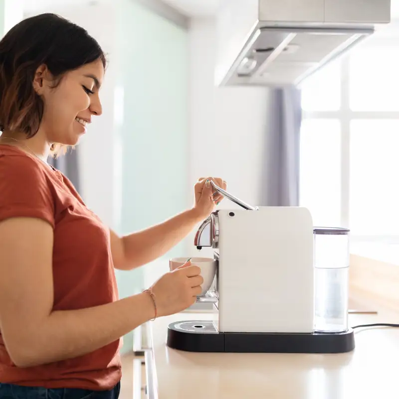 Mujer con cafetera de cápsulas