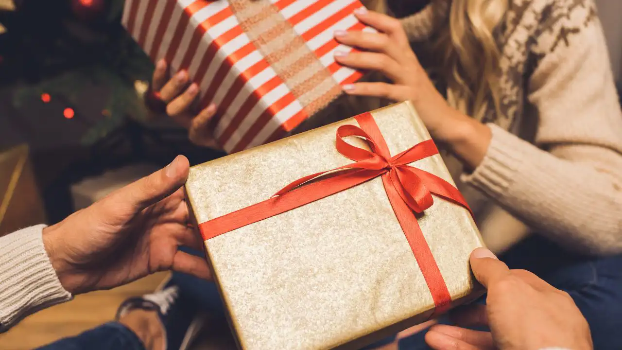 Pareja entregándose regalos de Navidad