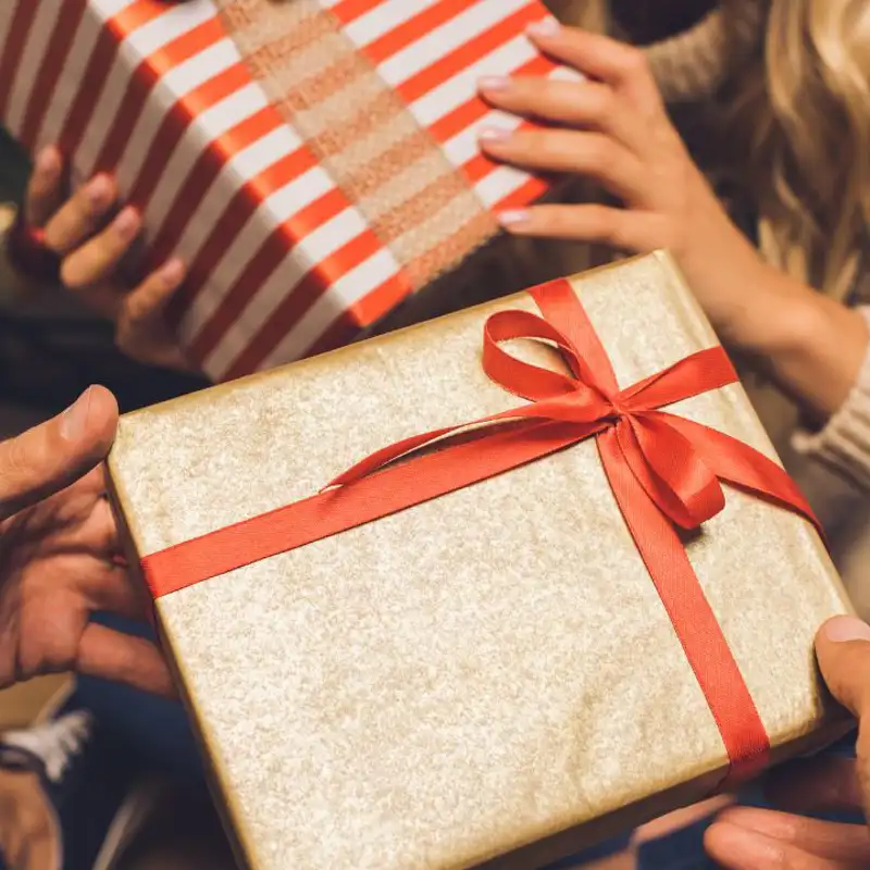 Pareja entregándose regalos de Navidad