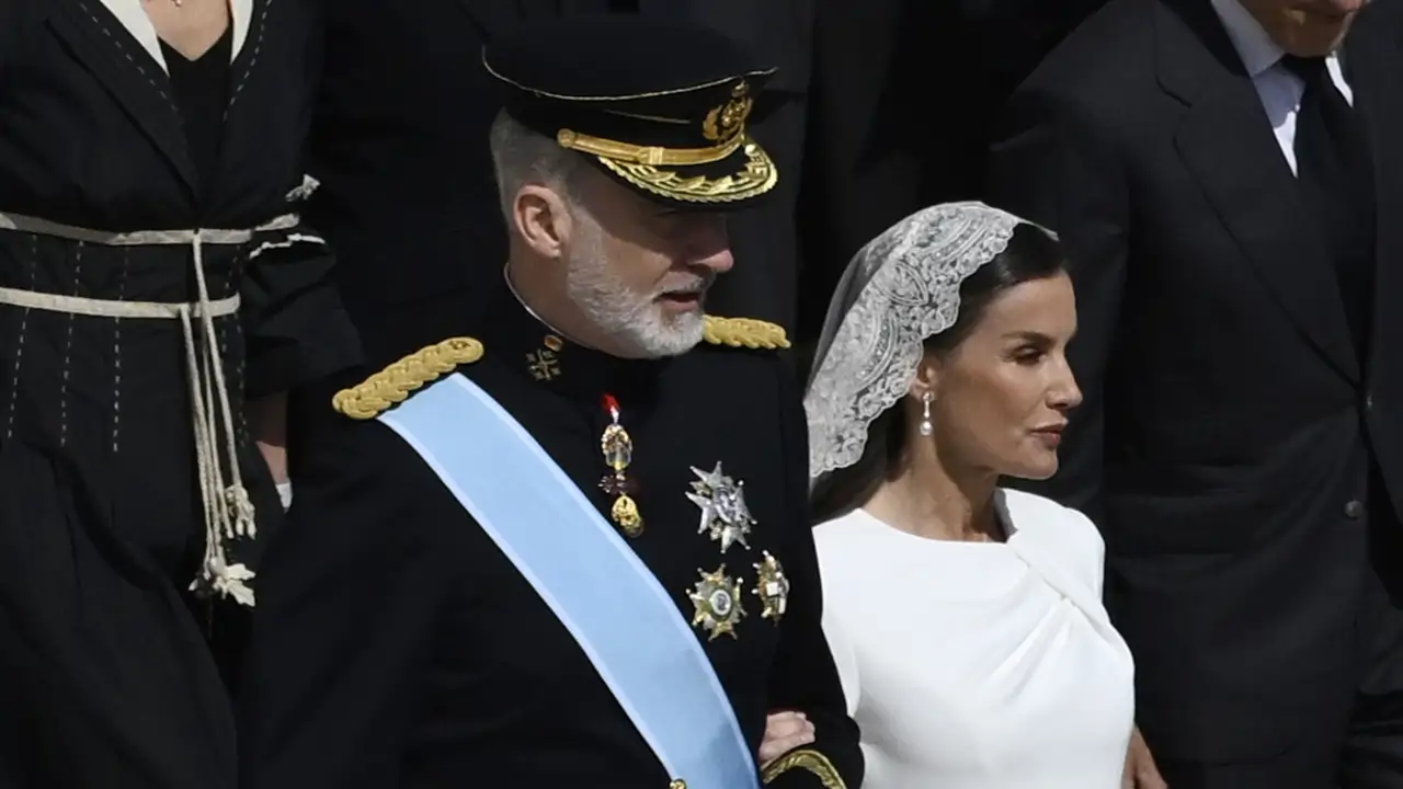 La reina Letizia, impecable de blanco en la misa inaugural del papa León XIV, cumple con el protocolo con una delicada mantilla y el vestido midi drapeado más elegante