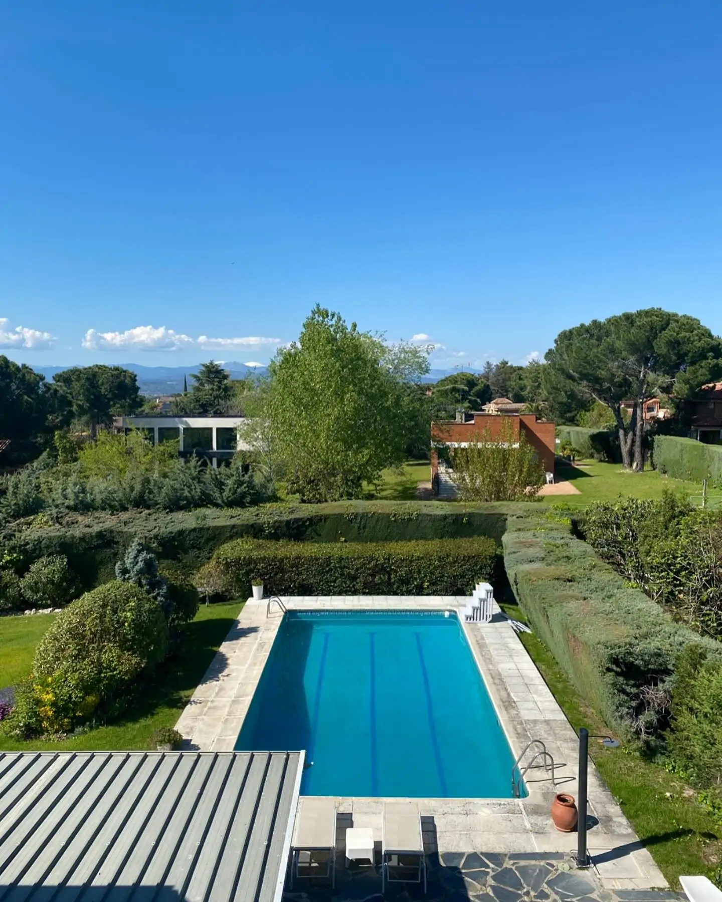 Un jardín con piscina y vistas a la sierra de Madrid