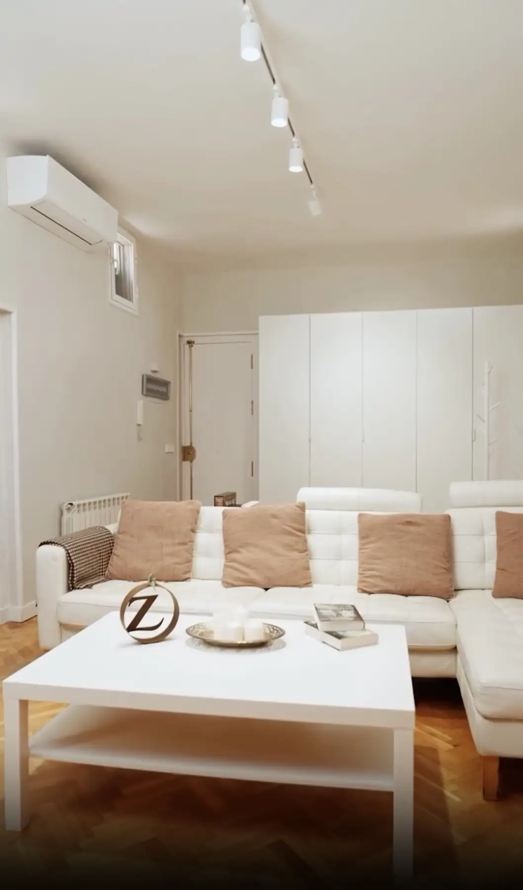 Un sofá con chaise longue blanco y capitoné