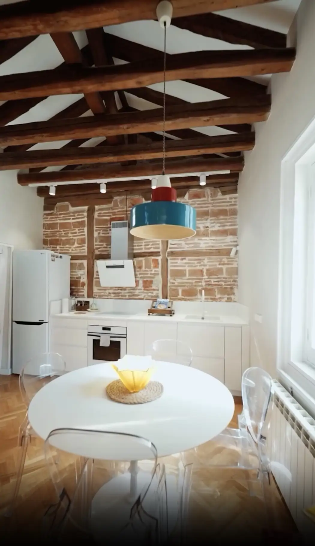 Un pequeño comedor con mesa y sillas transparentes